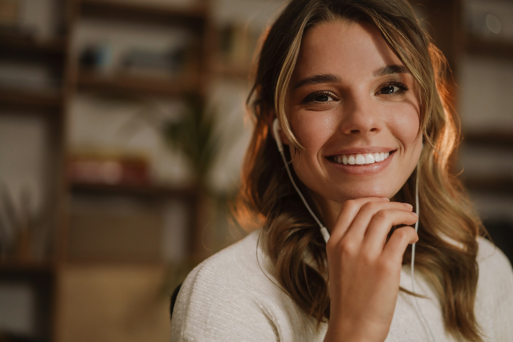 Close up of a pretty smiling woman in earphones