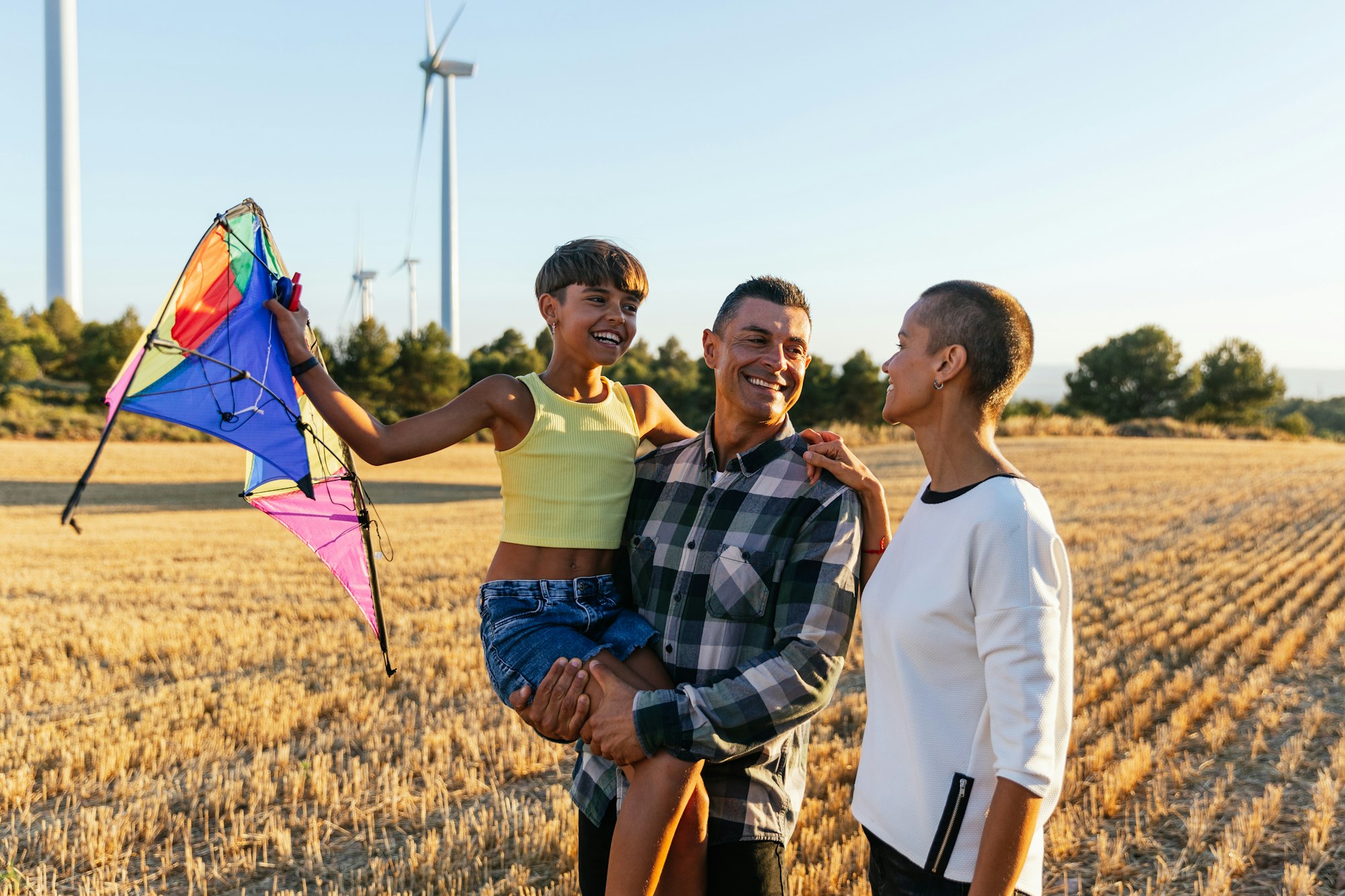 Smiling family having a fun day on a farm with windmills.