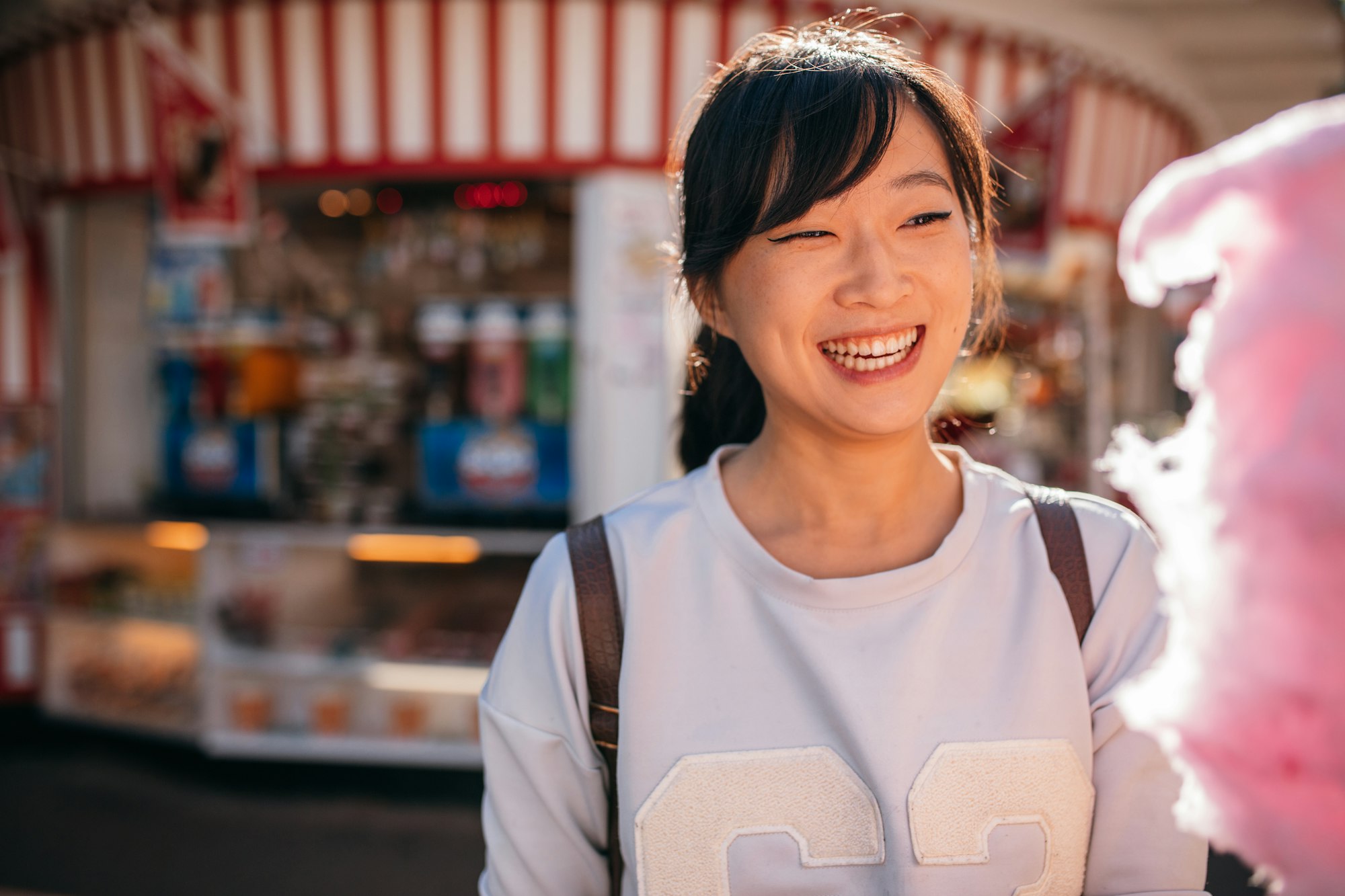 Young woman at amusement park with candy floss